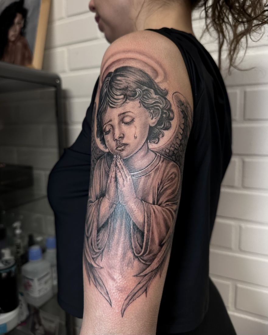 Praying angel on the upper arm, black and grey
